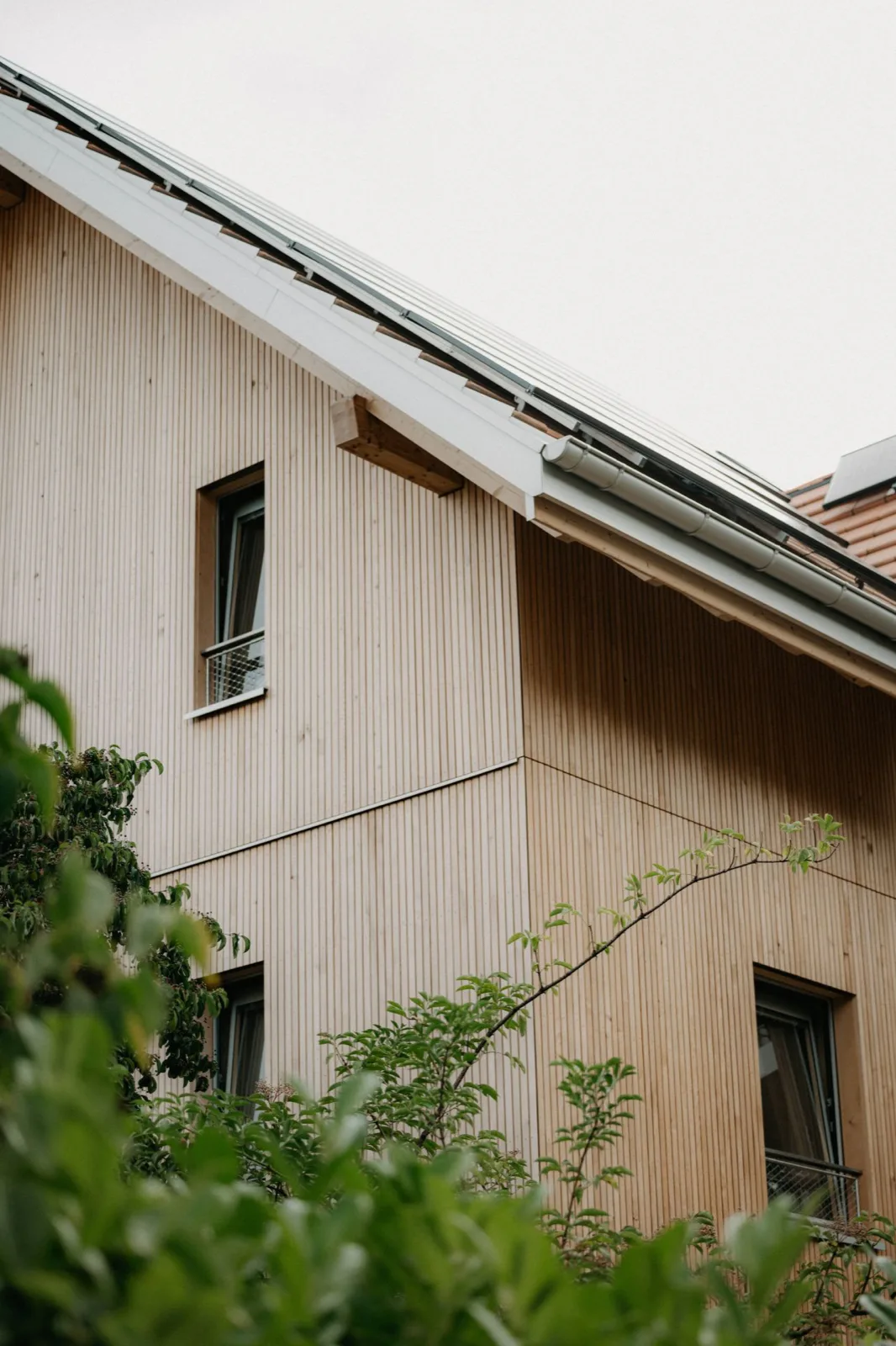 Holzfassade eines Wohnhauses im Tageslicht.