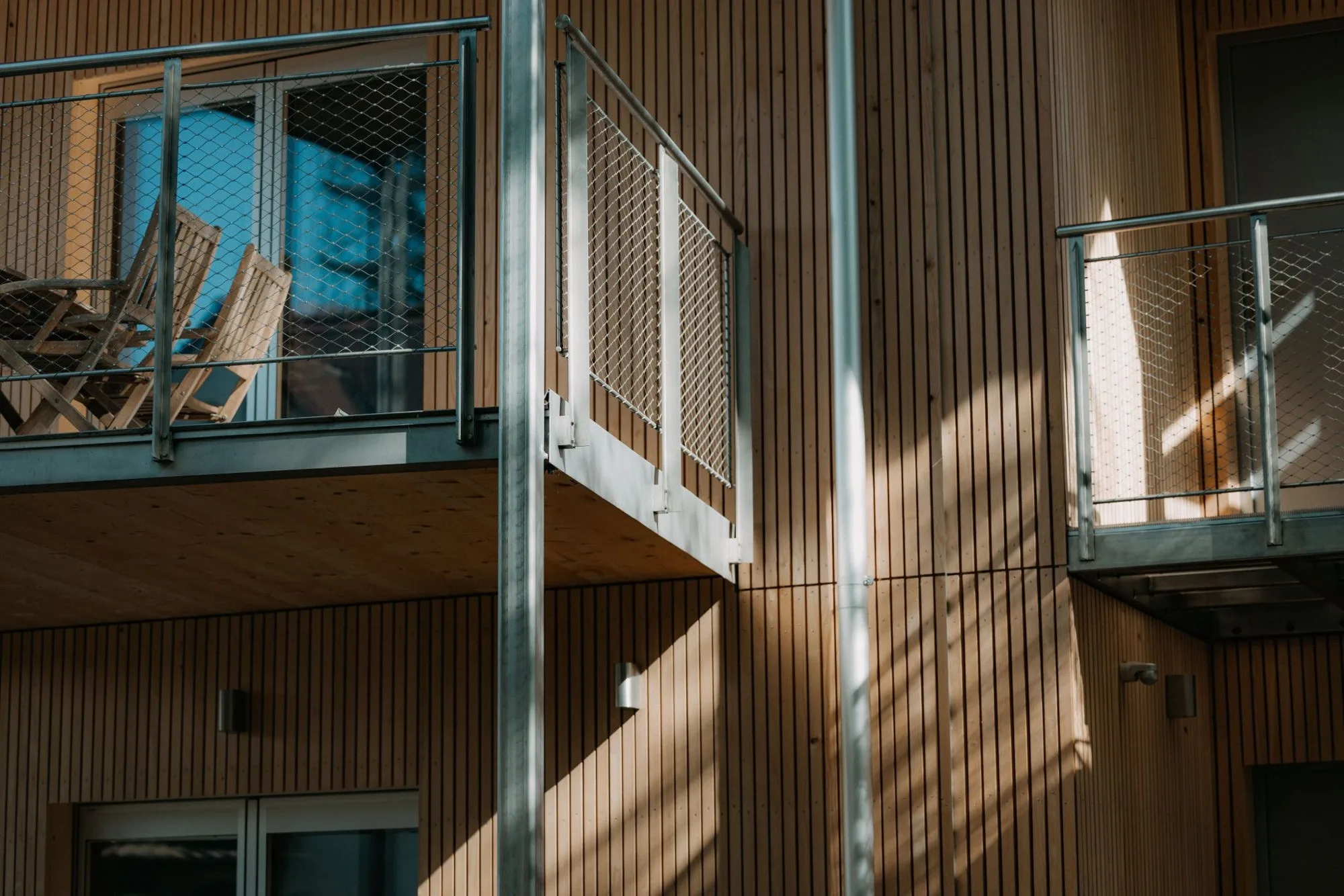 Mondholz-Fassade mit Balkonen im Tageslicht, Pratteln