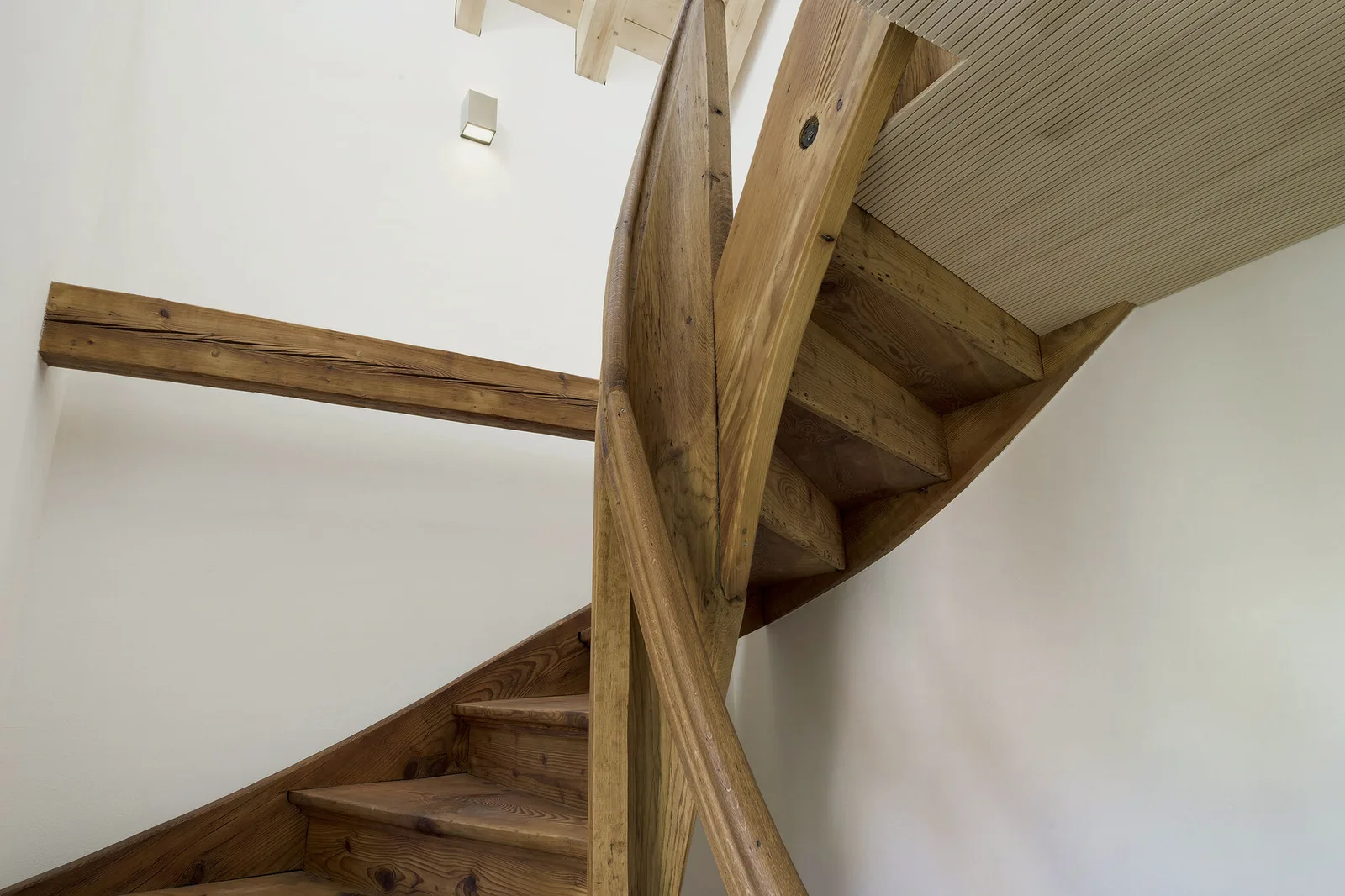 Holzwendeltreppe mit geölter Stufe und Handlauf.